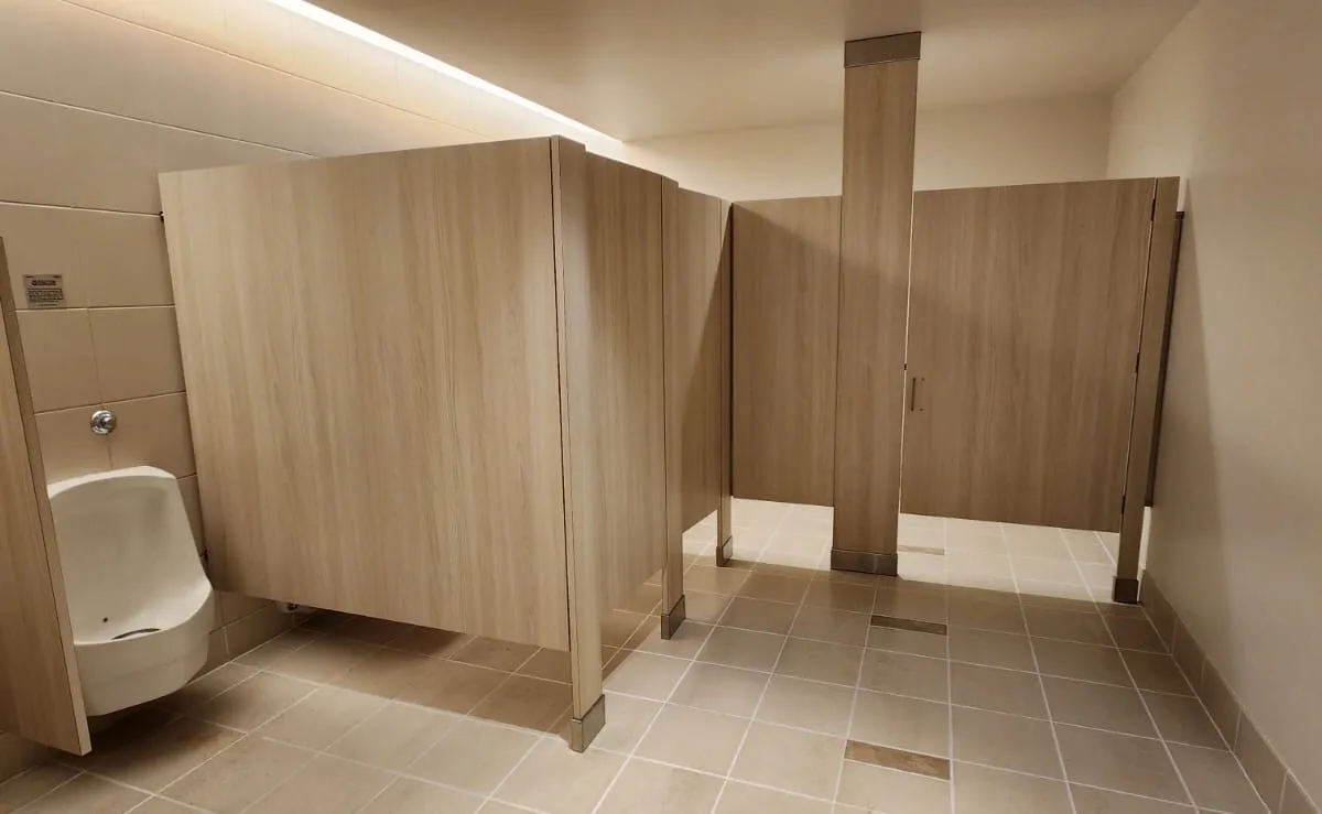 Wood-grain phenolic toilet partitions installed in a commercial restroom